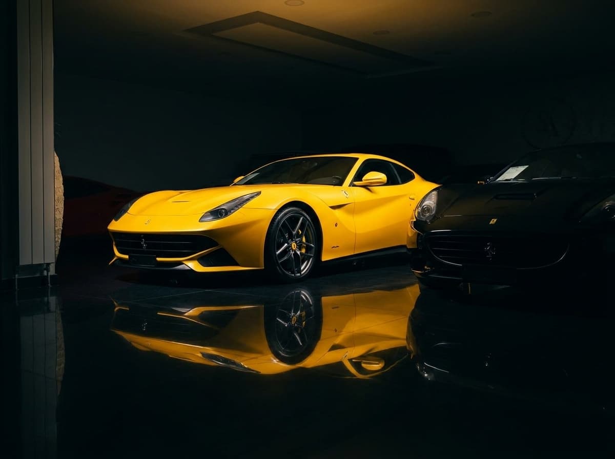 Gelber Ferrari F12 neben schwarzem Ferrari California im nächtlichen Showroom von Sternenfeld Autocenter, Birsfelden
